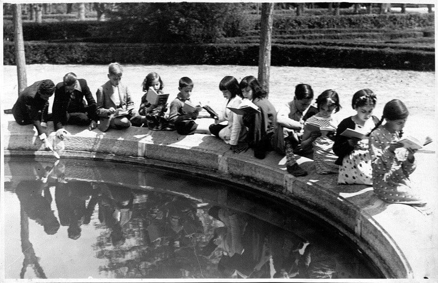 Niños leyendo en la biblioteca del parterre del Retiro