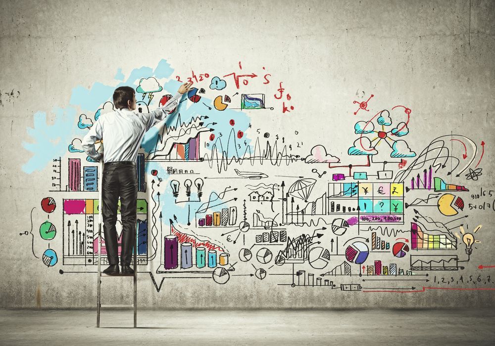 Back view of businessman drawing sketch on wall from Shutterstock